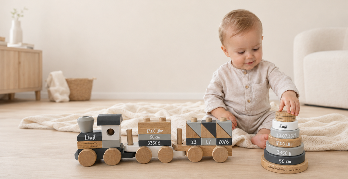 Baby mit personalisiertem Holzzug und Geburtsdaten als Motiv zu Vornamen-Trends 2026 und 2027