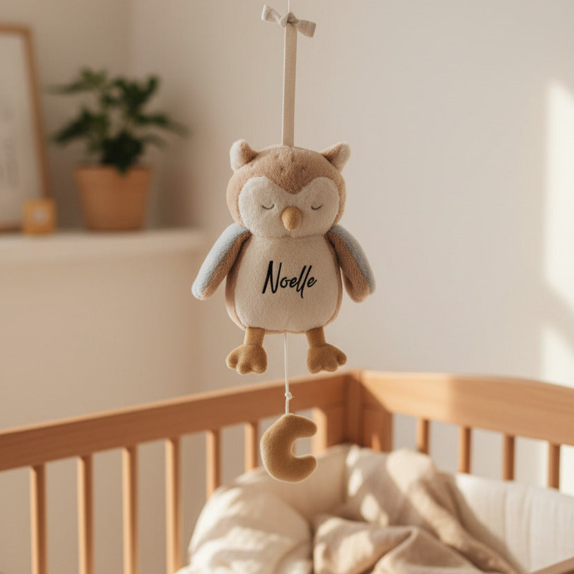 Personalisiertes Musik-Mobile mit Eule über einem Babybett im Kinderzimmer
