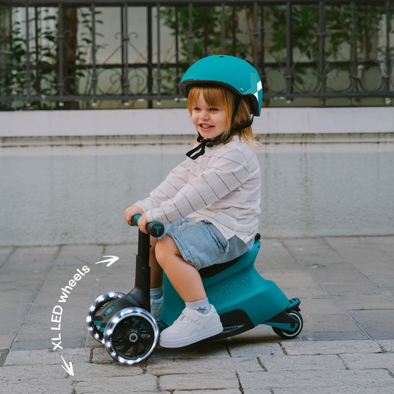 Kind faehrt Kinder Scooter mit Sitz und LED Raedern im Alltag draussen