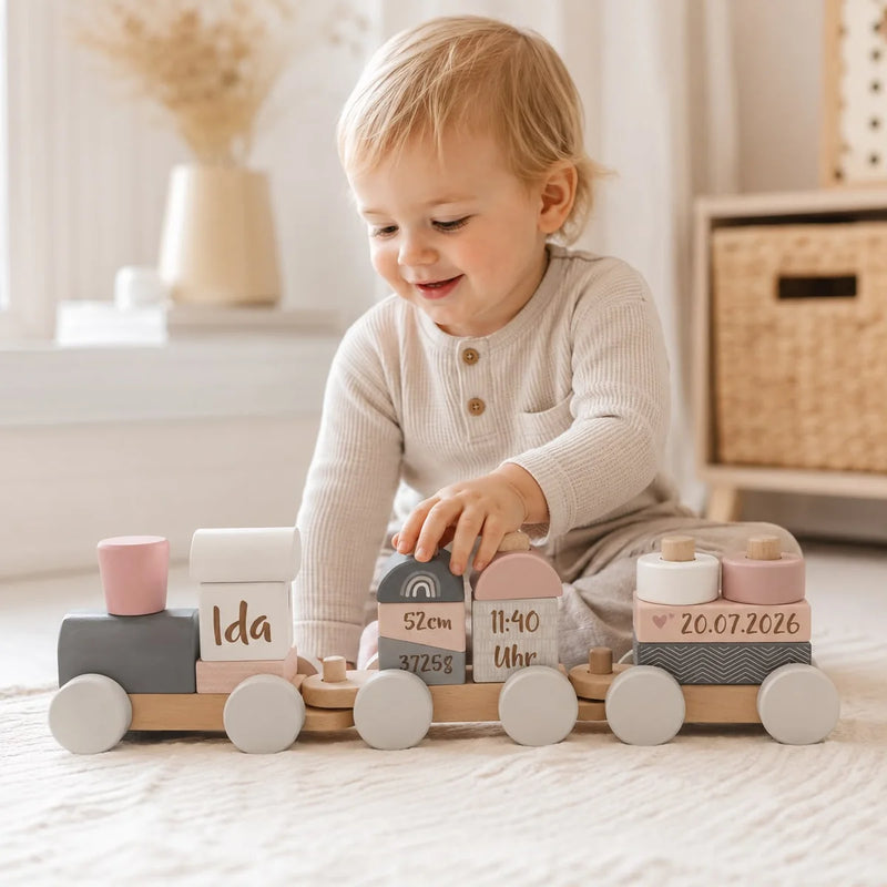 Kind spielt mit personalisiertem Holzzug in Rosa aus Holz mit Name, Geburtsdaten und Wunschgravur