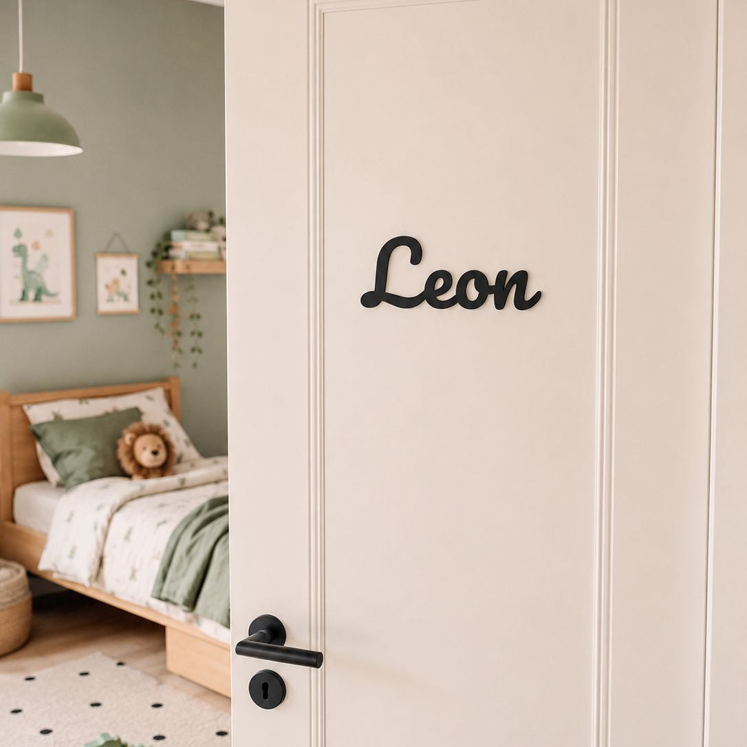 Personalisiertes Türschild Leon in Schwarz an weißer Kinderzimmertür mit grünem Kinderzimmer im Hintergrund