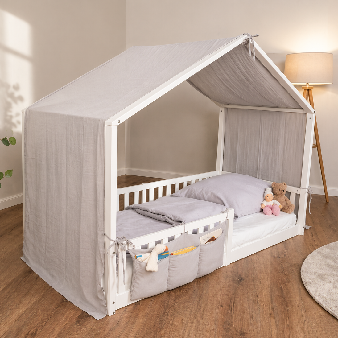 tiSsi Musselin Baldachin in Grau auf weißem Hausbett mit Organizer in gemütlicher Kinderzimmerumgebung