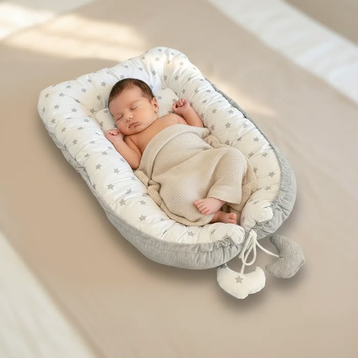 Schlafendes Baby im wendbaren Baby Bettnest von tiSsi in sanften Naturfarben – hochwertige Baby-Erstausstattung bei Schmatzepuffer