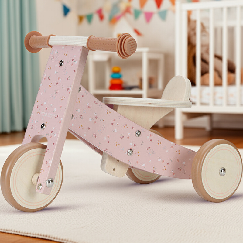 rosa Laufrad aus Holz für Babys im Kinderzimmer – stilvolles Geschenk für Kleinkinder