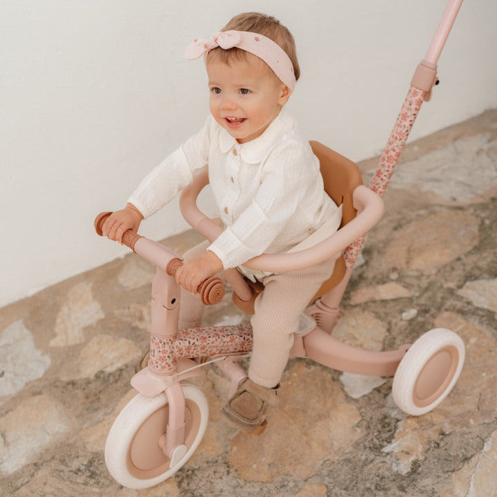 Mitwachsendes 4-in-1 Dreirad Fairy Floral Rosa für Kinder ab 1 Jahr mit Schubstange und Sicherheitsring. Kleinkind fährt auf hochwertigem Kinderdreirad in zarten Rosatönen und lernt spielerisch Balance, Koordination und erste Fahrbewegungen.
