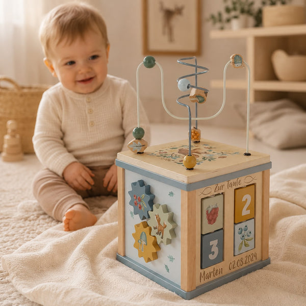Personalisierter Motorikwürfel zur Taufe mit Name und Datum von Schmatzepuffer – hochwertiges Holzspielzeug im warmen Lifestyle-Fotoshooting mit Baby im Hintergrund, besonderes Taufgeschenk und personalisierte Erinnerung