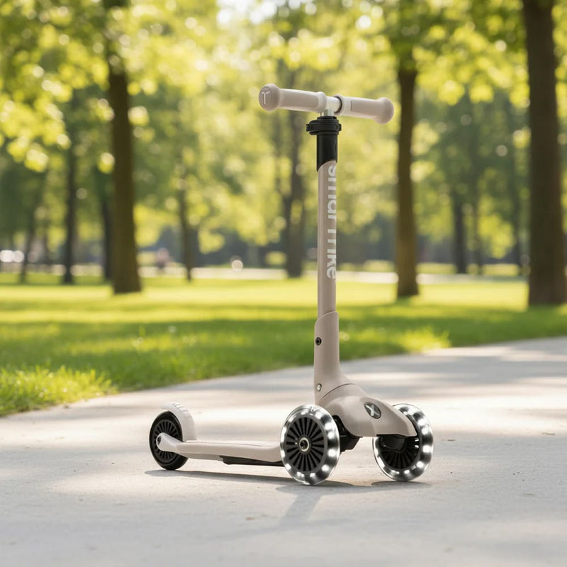 SmarTrike Xtend Scooter in Beige mit LED-Rädern auf einem sonnigen Parkweg – hochwertiger mitwachsender Kinderroller für Kinder